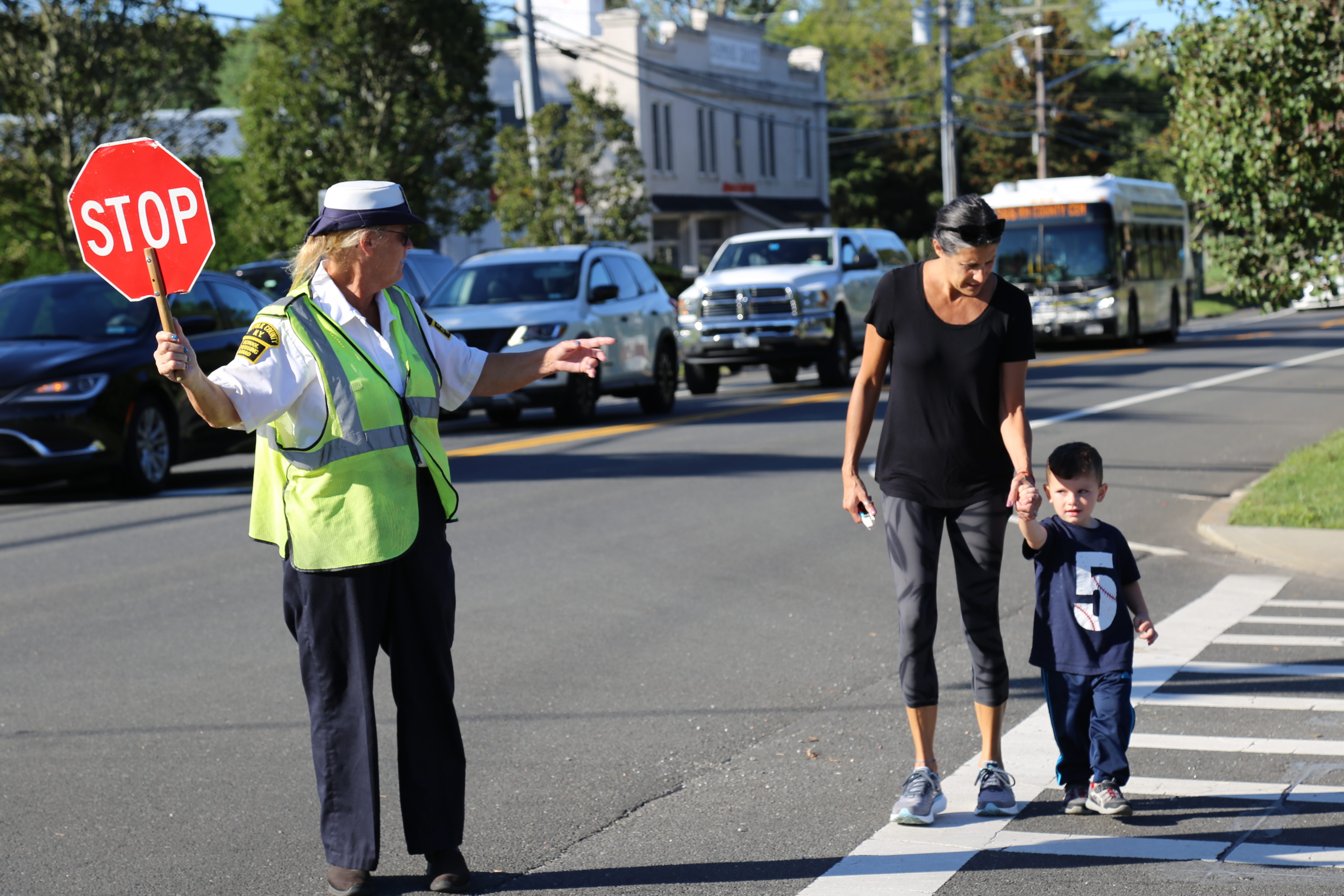 crossing guard helping family cross the street